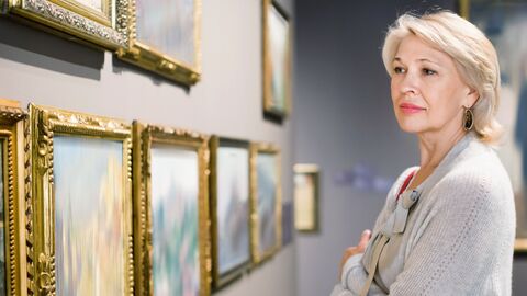 Eine Frau schaut sich Kunstwerke in einem Museum an.