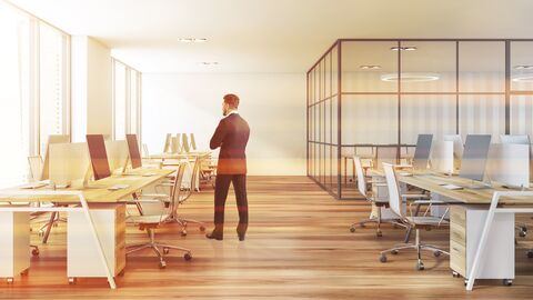 Ein Mann ist in einem Open Space Office zu sehen. 