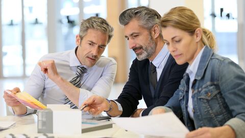 Im Wettbewerb um die besten städtebaulichen und architektonischen Lösungen führt der LBIH klar strukturierte und transparente Planungswettbewerbe durch.  Im Bild ist ein Team aus zwei Männern und einer Frau zu sehen. Sie arbeiten an einem Architekturmodell.