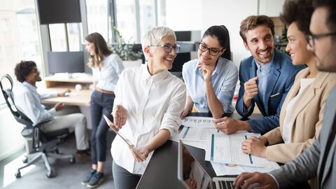Schuckbild Zertifizierung Personen in einem Büro an einem Schreibtisch mit Laptop und Unterlagen
