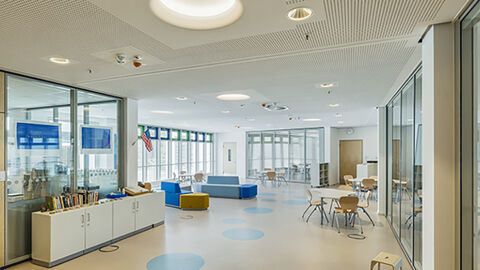 Dank der offenen Architektur stehen dem Nachwuchs der in Wiesbaden beheimateten U.S.-Streitkräfte anregende und ansprechende Arbeitsräume sowie lebendige Orte der Begegnung zur Verfügung.  Im Bild ist ein heller, offener Raum des Erweiterungsbaus der High School am Schulcampus US-Liegenschaft Hainerberg zu sehen.