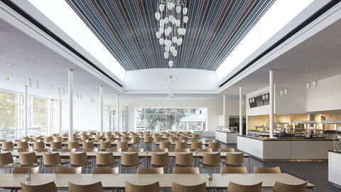 Im Bild ist der Innenraum des Kasinos des Statistischen Bundesamts zu sehen. Die helle Kantine versorgt die Mitarbeiter*innen des Statistischen Bundesamts und externe Besucher*innen mit ca. 1.000 Essen pro Tag.