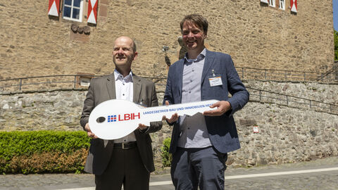 Leonhard Lemke, Leiter der LBIH-Niederlassung Nord, und DJH Hessen Vorstand, Knut Stolle, halten den Übergabeschlüssel in der Hand.