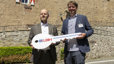 Leonhard Lemke, Leiter der LBIH-Niederlassung Nord, und DJH Hessen Vorstand, Knut Stolle, halten den Übergabeschlüssel in der Hand.